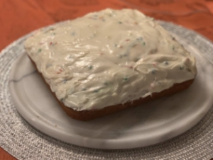vanilla cake with funfetti icing on a plate 