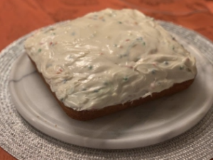 vanilla cake with funfetti icing on a plate